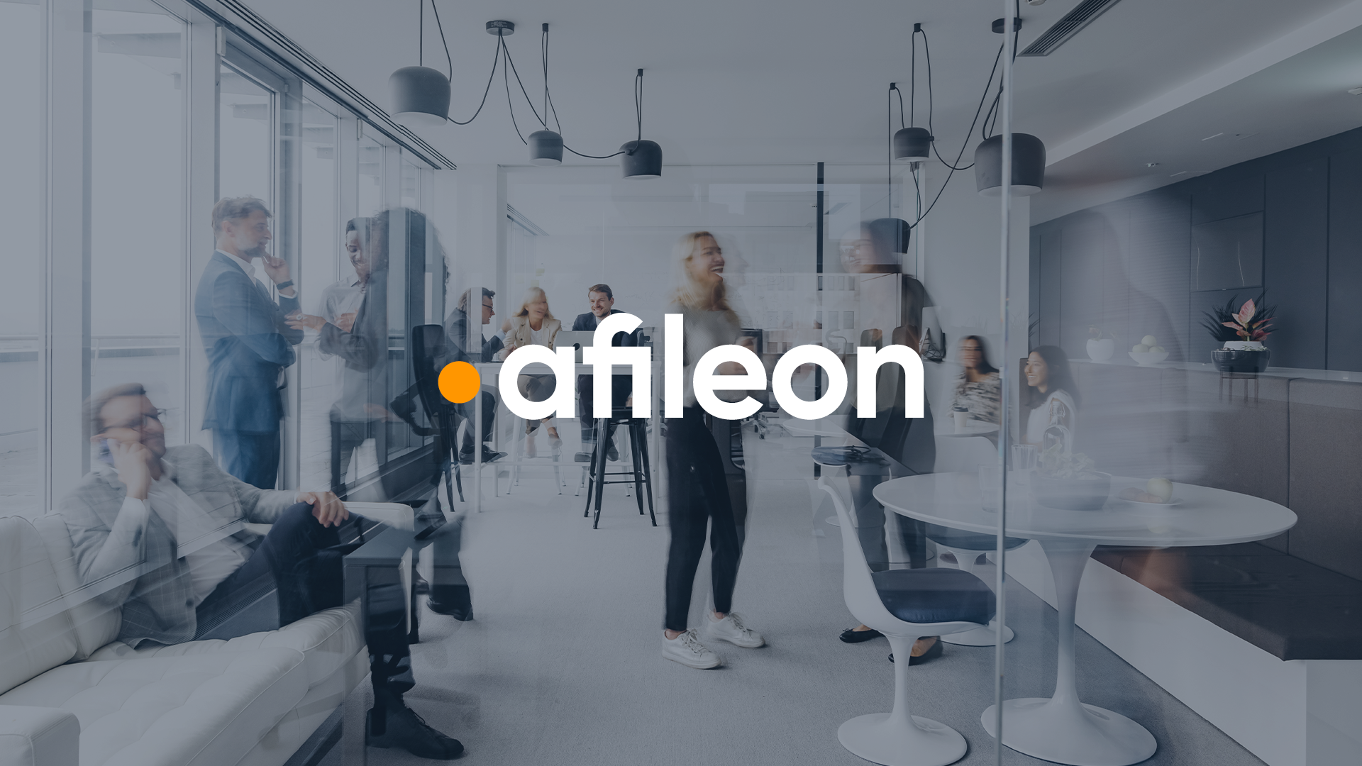 Ein modernes Büro mit mehreren Menschen, die in Gruppen miteinander sprechen oder arbeiten. Im Vordergrund sind eine Gruppe von Personen in lebhaften Gesprächen zu sehen, während im Hintergrund andere Personen am Tisch sitzen oder stehen. Das Logo "afileon" ist prominent in der Mitte des Bildes platziert.